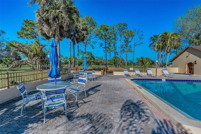 community pool featuring a patio area and fence