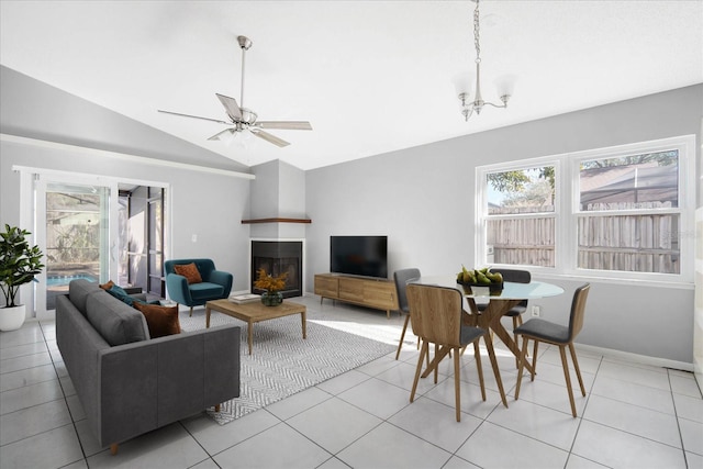 living room with light tile patterned flooring, lofted ceiling, and ceiling fan with notable chandelier