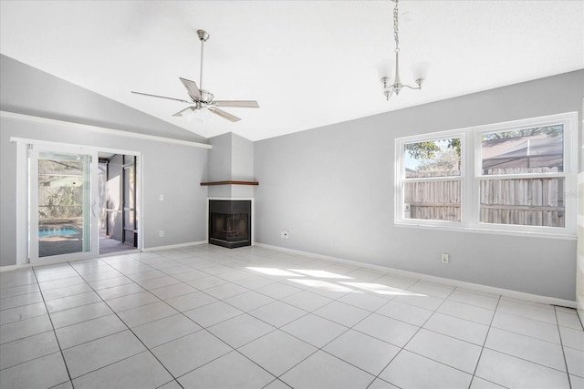 unfurnished living room with vaulted ceiling, ceiling fan with notable chandelier, and light tile patterned floors