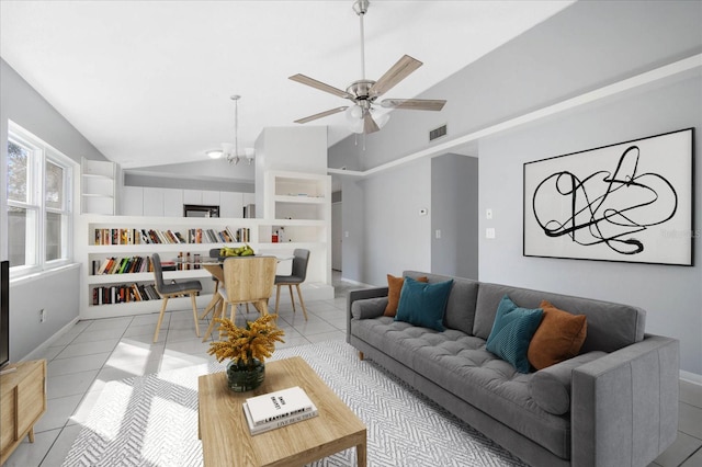 living room featuring ceiling fan with notable chandelier, vaulted ceiling, and light tile patterned flooring