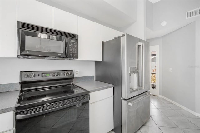 kitchen with light tile patterned flooring, white cabinets, and black appliances