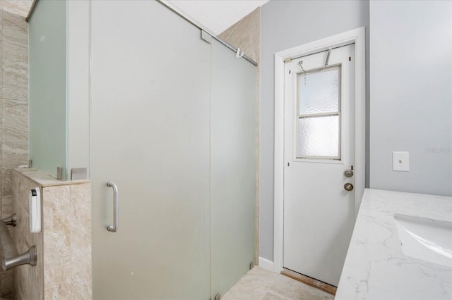 bathroom with vanity and a shower with door