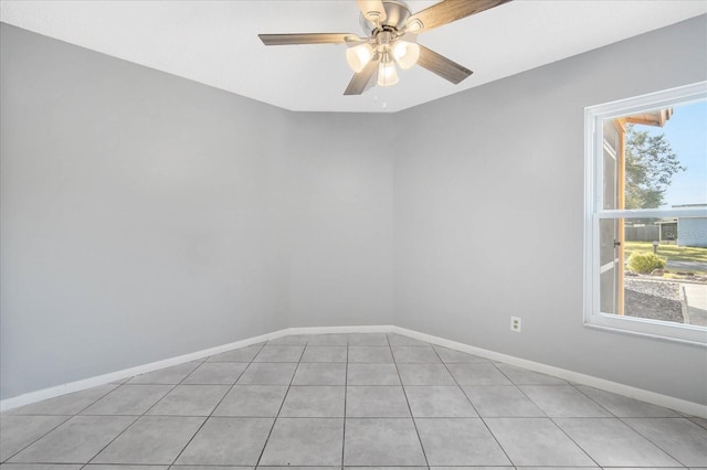 tiled empty room featuring a wealth of natural light and ceiling fan