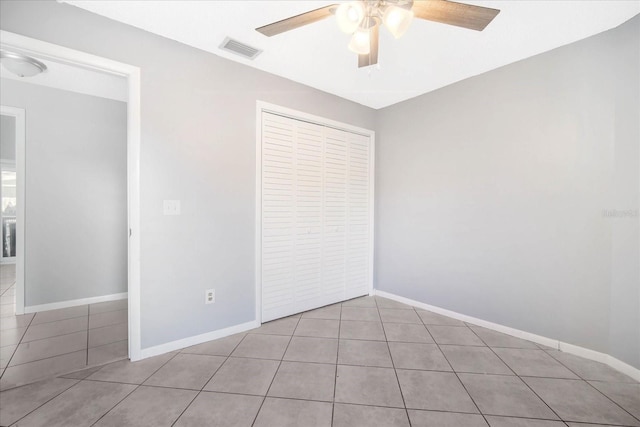 unfurnished bedroom with a closet, ceiling fan, and light tile patterned flooring