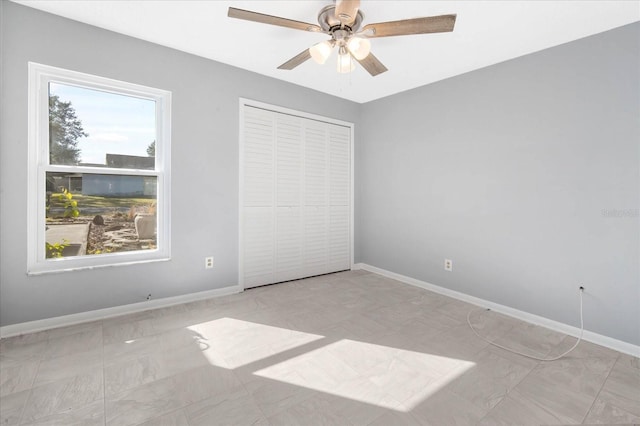 unfurnished bedroom featuring multiple windows, ceiling fan, and a closet