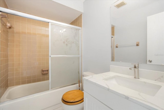 full bathroom featuring vanity, shower / bath combination with glass door, and toilet