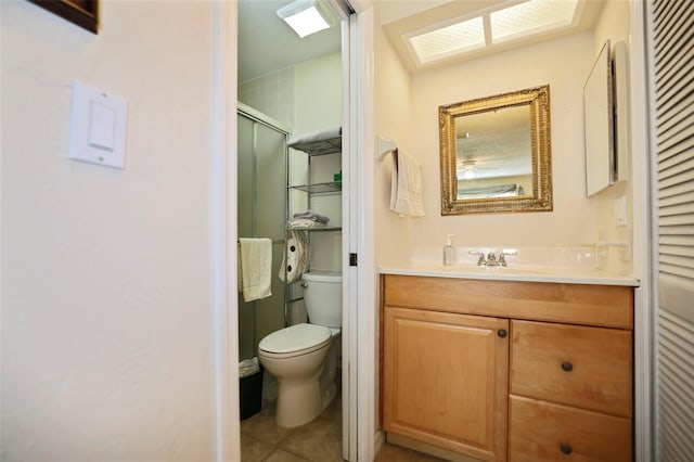 bathroom with vanity, a shower with shower door, tile patterned floors, and toilet