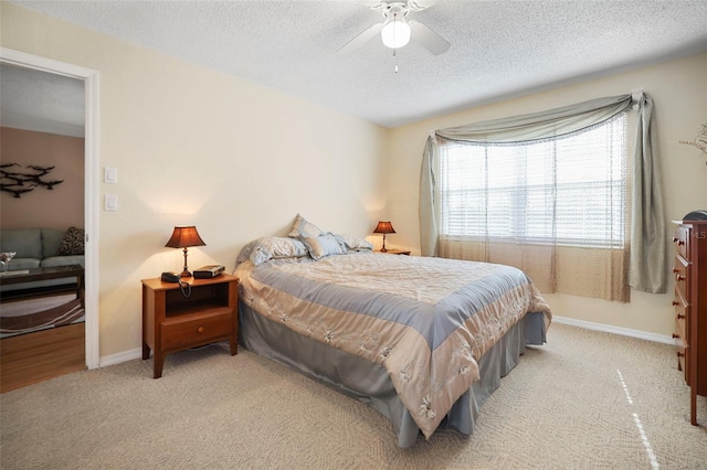 carpeted bedroom with ceiling fan and a textured ceiling