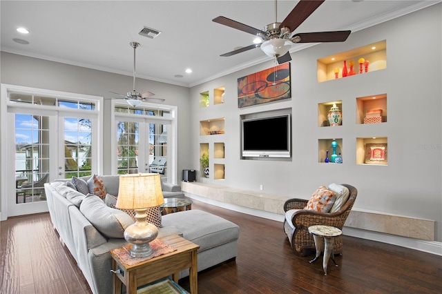 living room with crown molding, ceiling fan, dark hardwood / wood-style flooring, built in shelves, and french doors