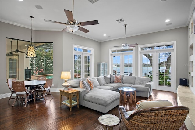 living room with french doors, a water view, crown molding, and dark wood-type flooring