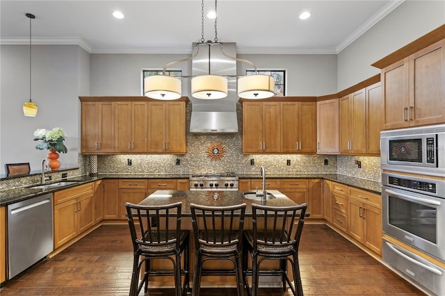 kitchen featuring hanging light fixtures, appliances with stainless steel finishes, sink, and a breakfast bar area