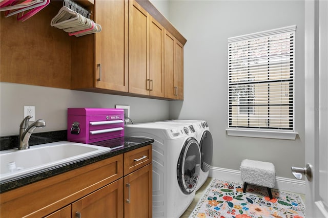 washroom with cabinets, sink, light tile patterned floors, and washer and clothes dryer