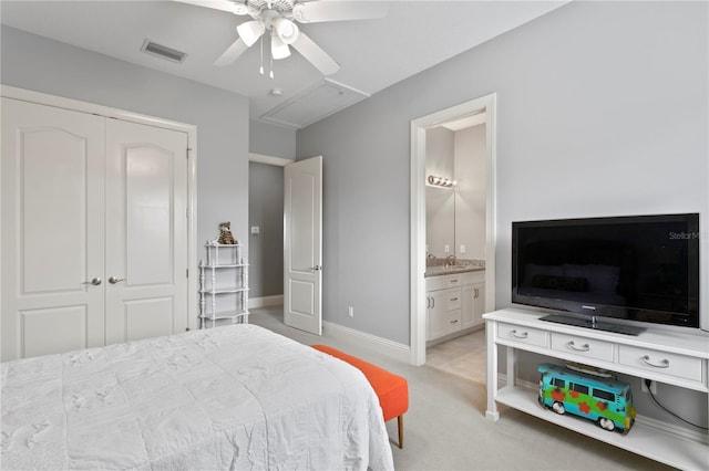 carpeted bedroom with a closet, ceiling fan, and ensuite bathroom