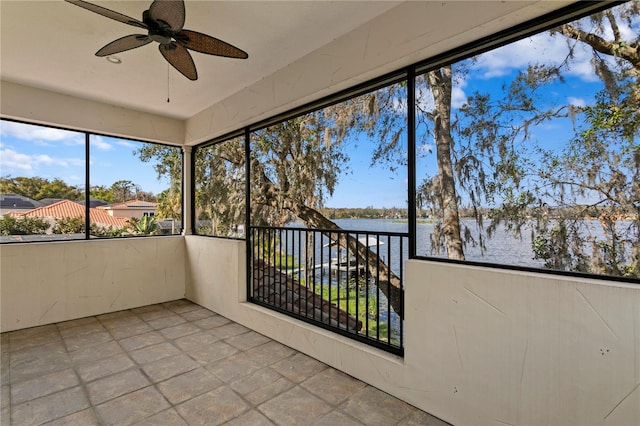 unfurnished sunroom featuring a water view and ceiling fan