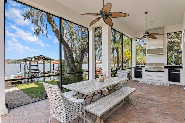 sunroom / solarium featuring a water view and ceiling fan