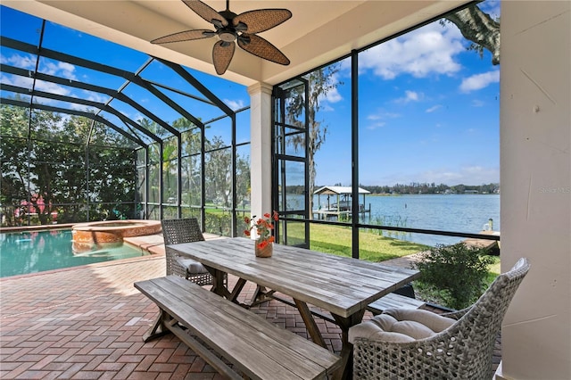 sunroom / solarium with a water view and ceiling fan