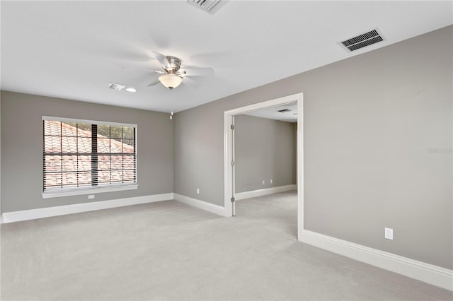 empty room with ceiling fan and light carpet