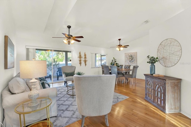 living room featuring vaulted ceiling, ceiling fan, and light wood-type flooring