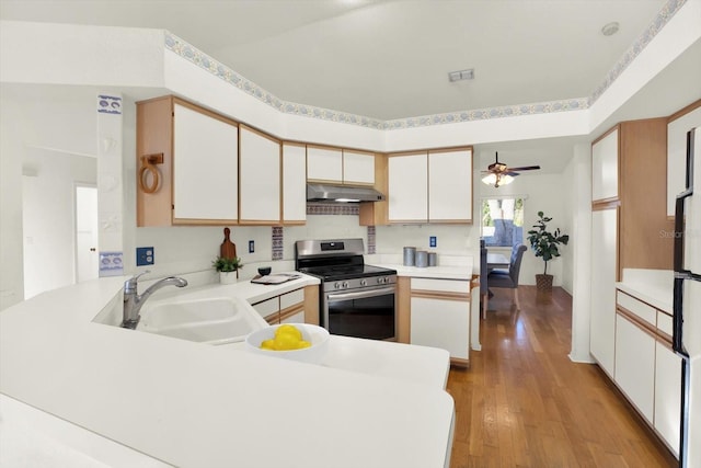 kitchen featuring sink, light hardwood / wood-style flooring, white cabinetry, stainless steel electric stove, and kitchen peninsula