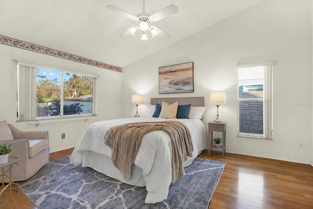 bedroom featuring multiple windows, hardwood / wood-style flooring, vaulted ceiling, and ceiling fan