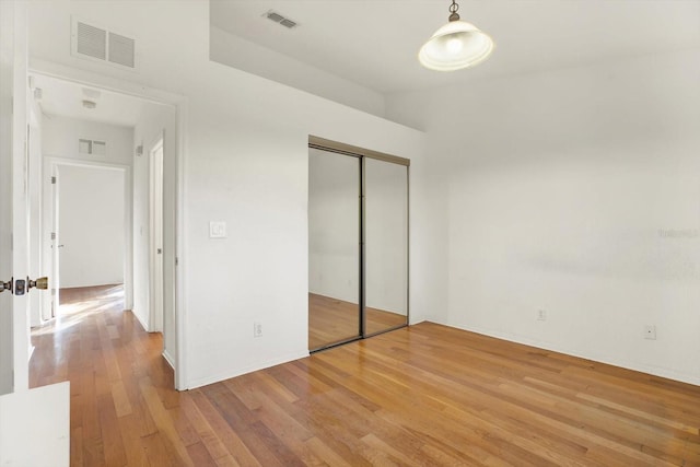 unfurnished bedroom with light hardwood / wood-style floors and a closet