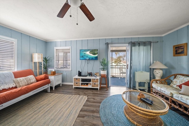 living room featuring ceiling fan, crown molding, dark wood-type flooring, and a textured ceiling