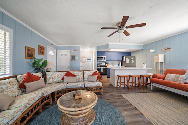 living room with crown molding, dark hardwood / wood-style floors, and ceiling fan