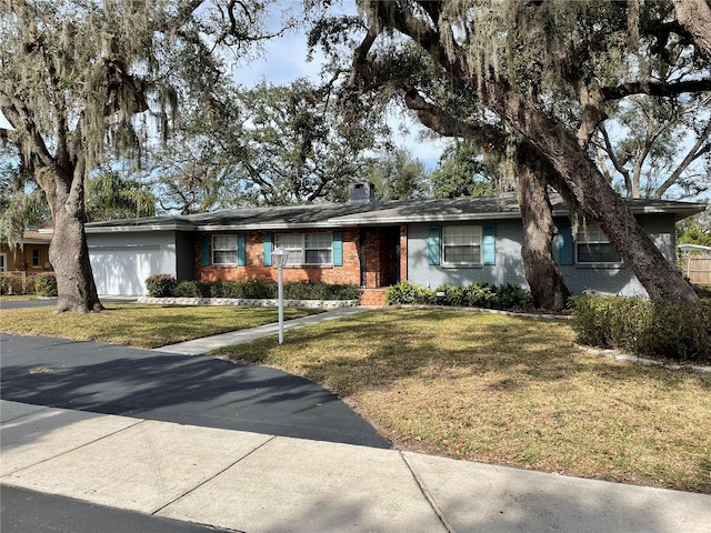 ranch-style house featuring a garage and a front lawn