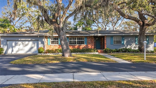 single story home featuring a garage and a front lawn