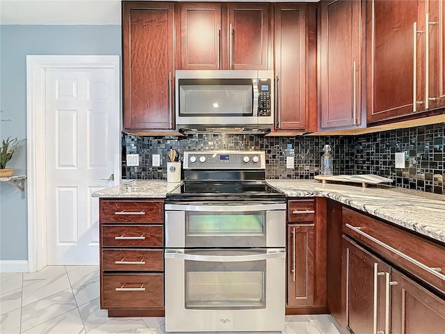 kitchen with light stone counters, stainless steel appliances, and backsplash