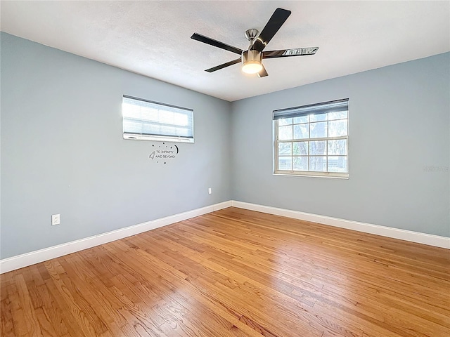 empty room with ceiling fan, a healthy amount of sunlight, and light wood-type flooring