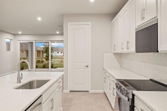 kitchen featuring sink, decorative backsplash, stainless steel appliances, and white cabinets