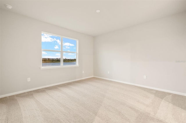 carpeted empty room with a water view