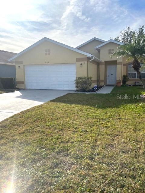 view of front of home with a garage and a front lawn