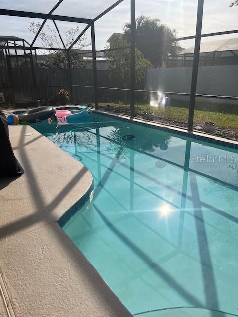 view of pool featuring glass enclosure