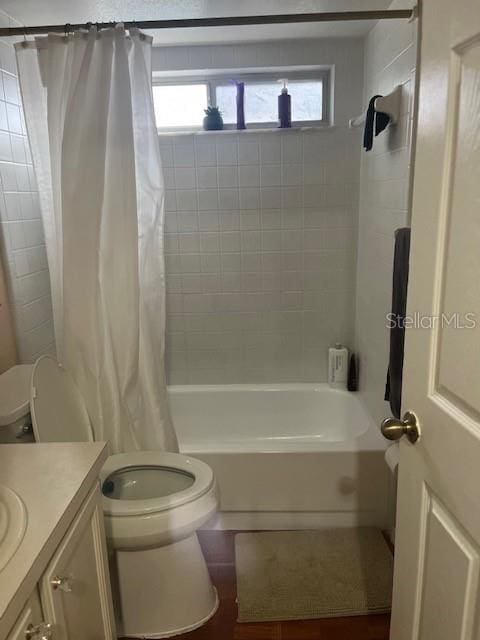 full bathroom featuring vanity, toilet, a healthy amount of sunlight, and shower / bathtub combination with curtain