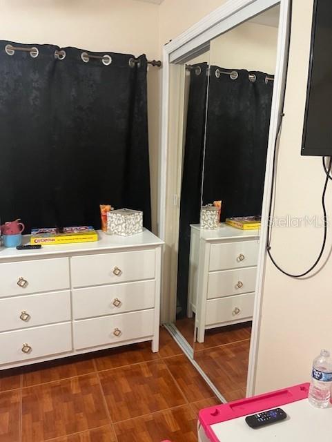 unfurnished bedroom with dark wood-type flooring and a closet