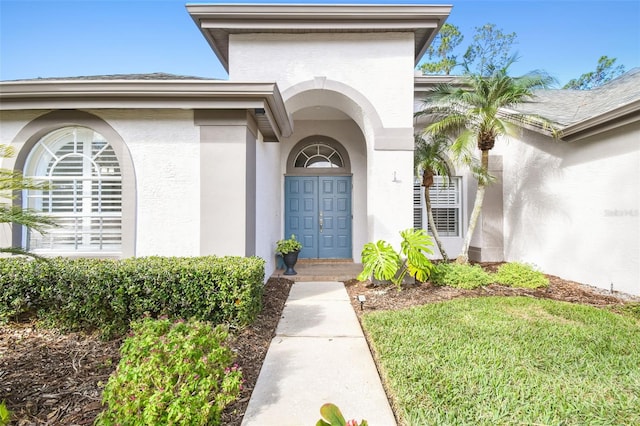 property entrance featuring a lawn