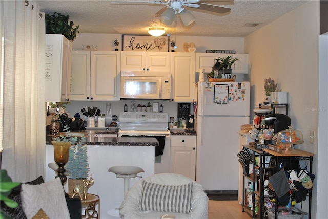 kitchen with white cabinetry, ceiling fan, white appliances, and a textured ceiling