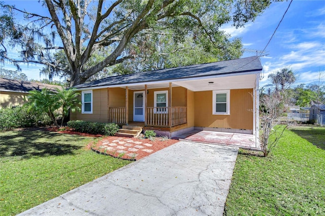 single story home featuring covered porch and a front lawn