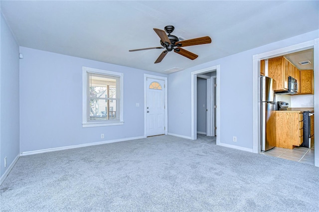 unfurnished living room featuring light carpet and ceiling fan