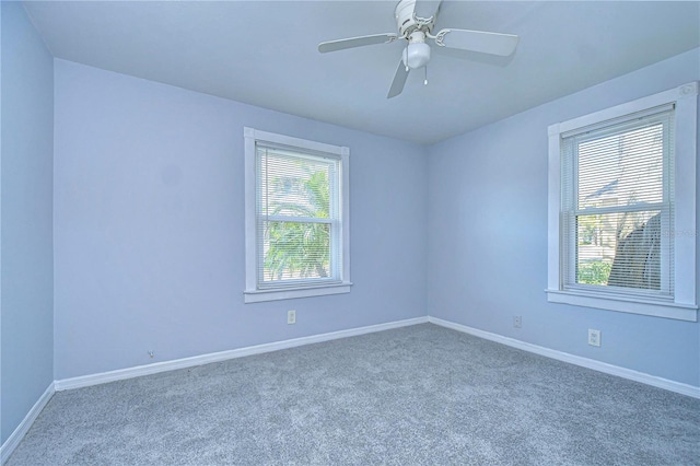 carpeted spare room featuring ceiling fan