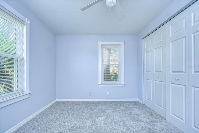 unfurnished bedroom with light carpet, multiple windows, and a closet