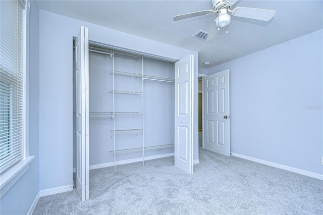 unfurnished bedroom with ceiling fan, light colored carpet, and a closet