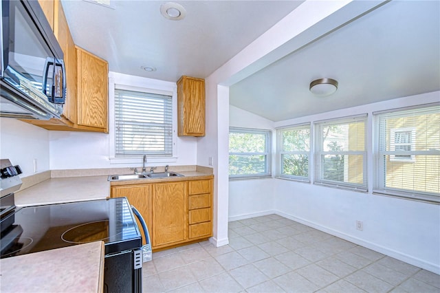 kitchen featuring sink, a wealth of natural light, light tile patterned floors, and electric stove