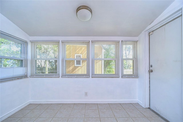 unfurnished sunroom featuring lofted ceiling and a healthy amount of sunlight