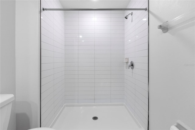 bathroom with tiled shower and toilet