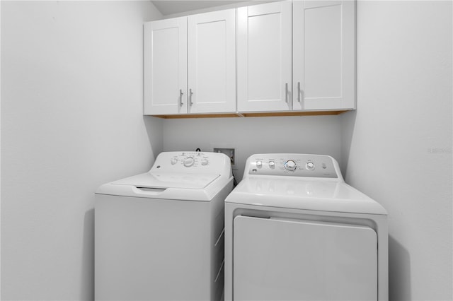 clothes washing area with independent washer and dryer and cabinets