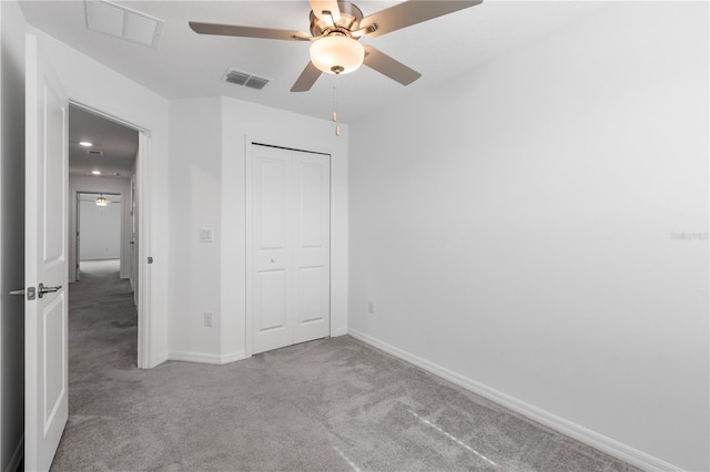 unfurnished bedroom featuring light colored carpet, a closet, and ceiling fan