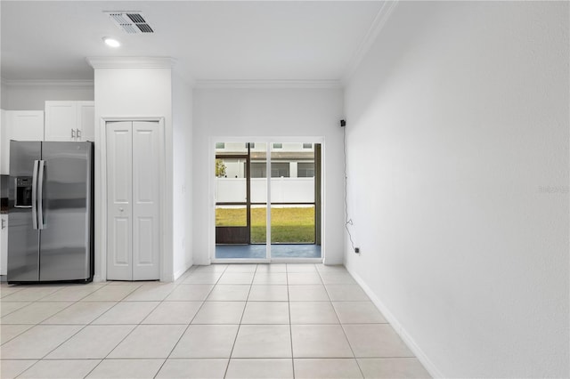 kitchen featuring stainless steel fridge with ice dispenser, light tile patterned floors, ornamental molding, and white cabinets